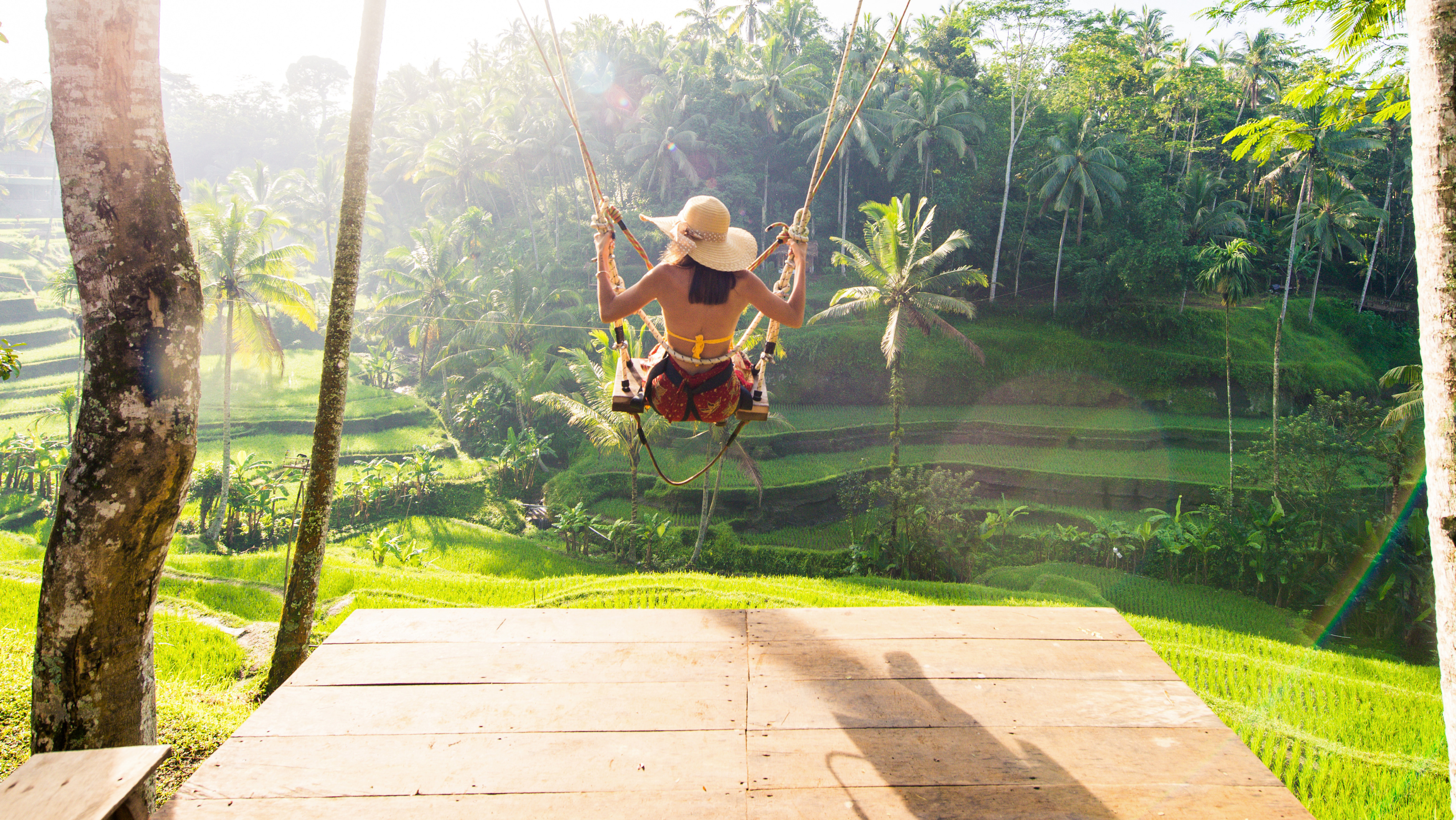 a girl on swing at rice paddies in Bali